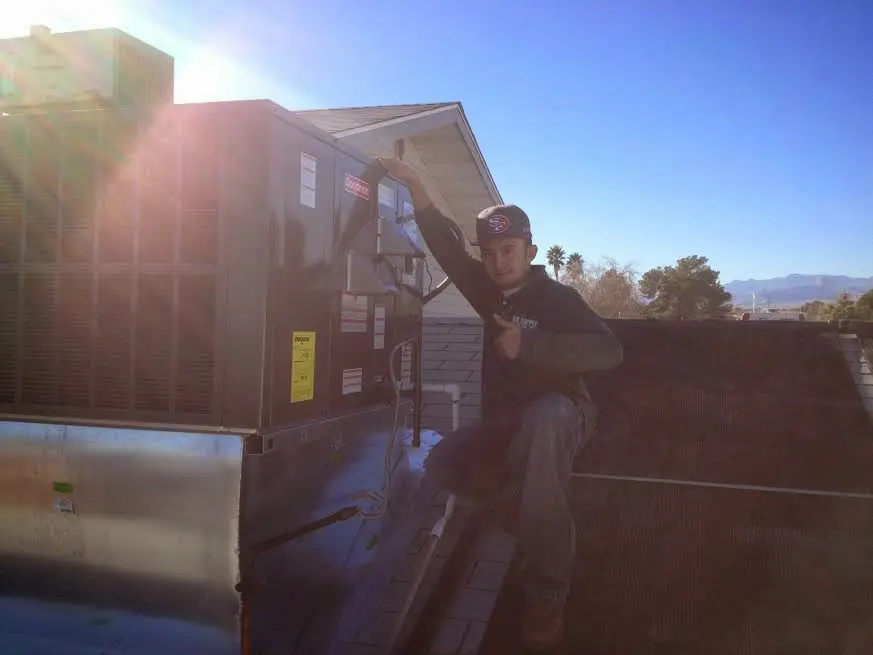 HVAC technician performing AC Tune-Up on a rooftop unit in Lincolnwood